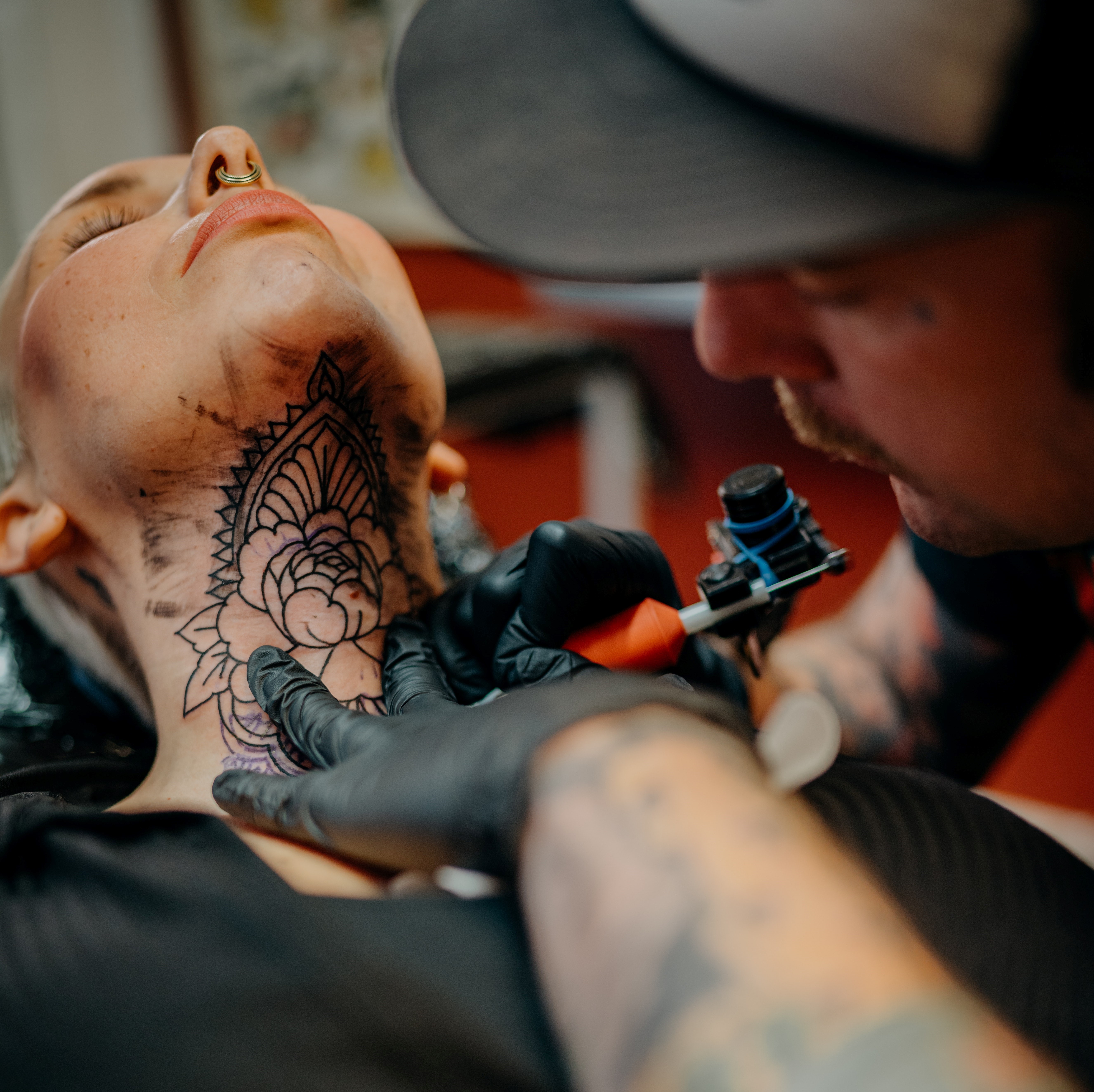 Tattoo artist tattooing neck